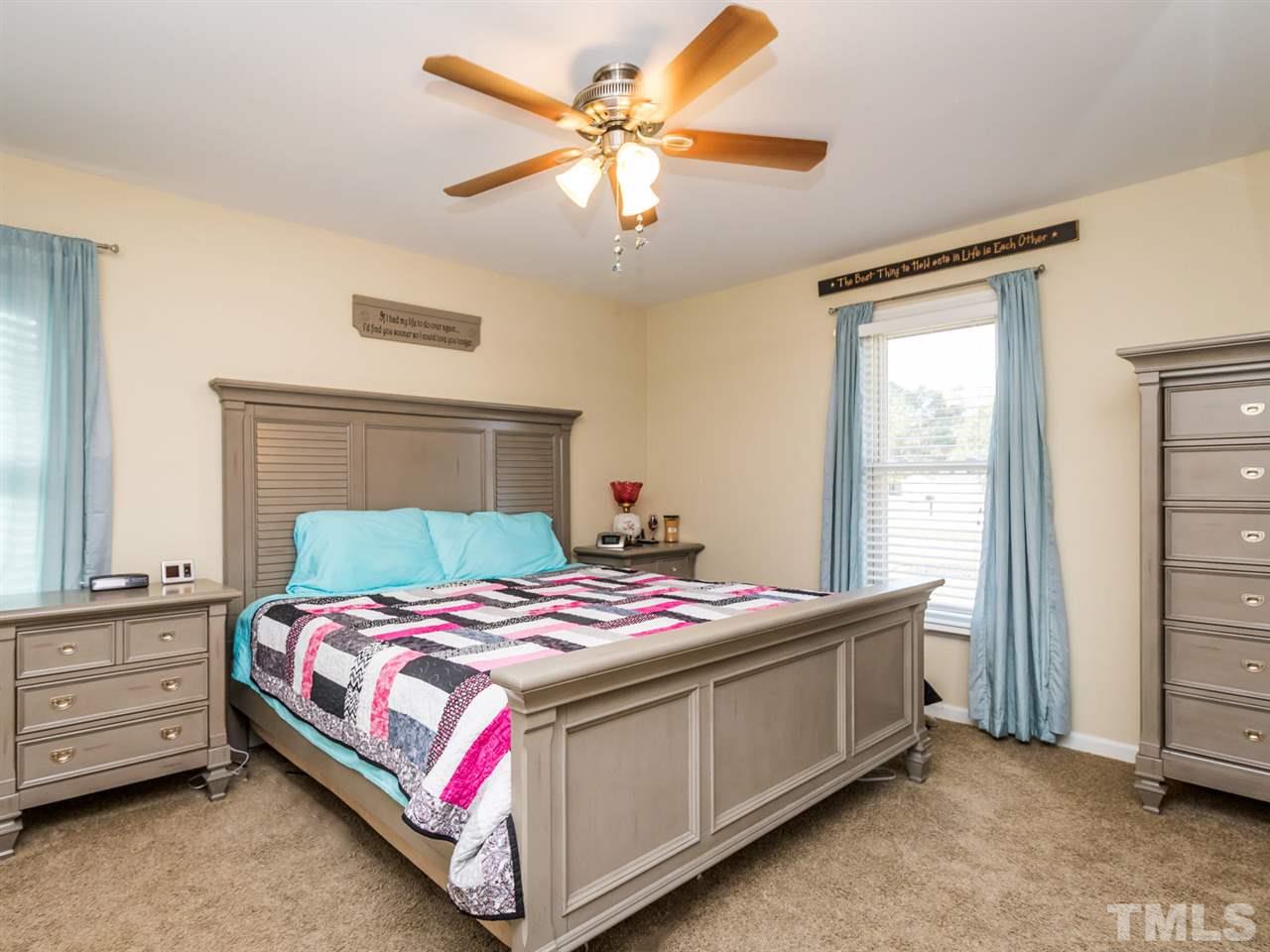 10017 Joe Leach Road Raleigh, NC 27603 - Photo 12 of 23 a bedroom with a bed and a chandelier