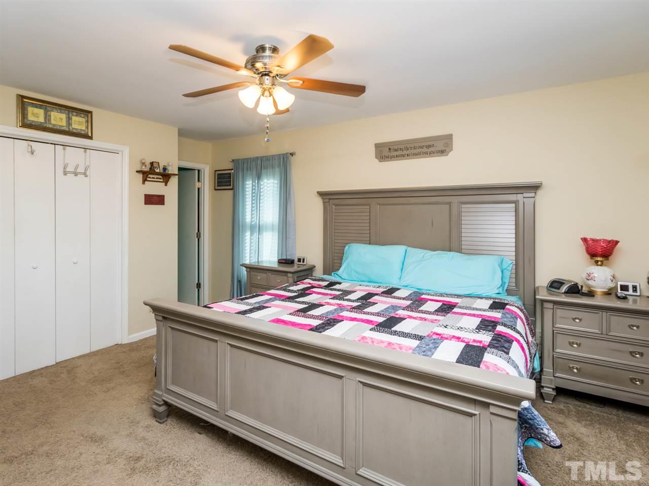 10017 Joe Leach Road Raleigh, NC 27603 - Photo 14 of 23 a bedroom with a bed and a chandelier