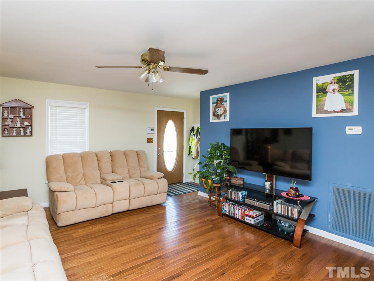 10017 Joe Leach Road Raleigh, NC 27603 - Photo 4 of 23 a living room with furniture and a flat screen tv