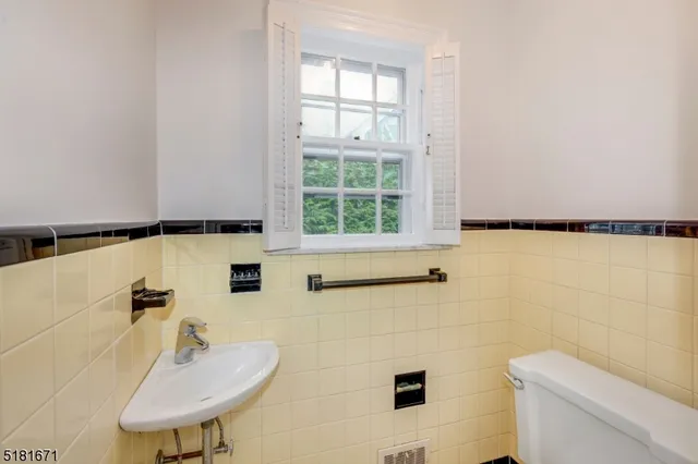 a bathroom with a sink a toilet and a mirror