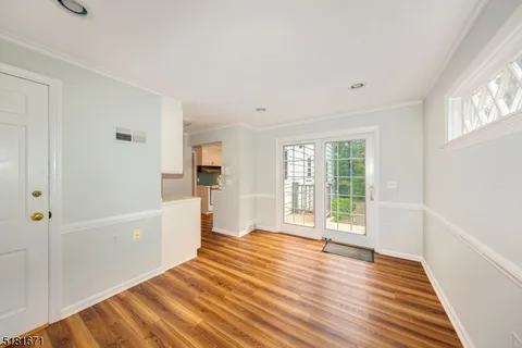 a view of a big room with wooden floor and windows