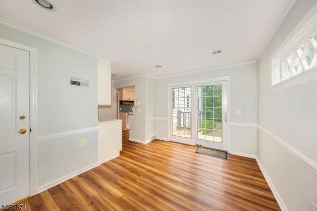 a view of a big room with wooden floor and windows