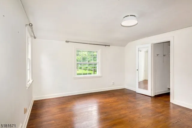 a view of a room with wooden floor and window