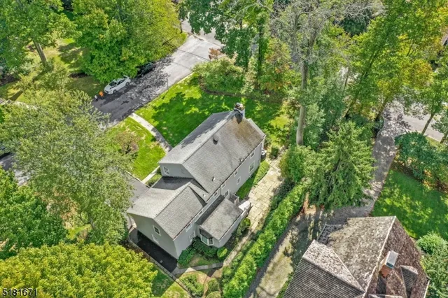 an aerial view of a house with a yard and large trees