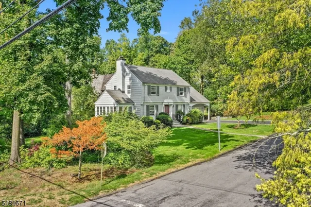 a front view of a house with a yard and potted plants