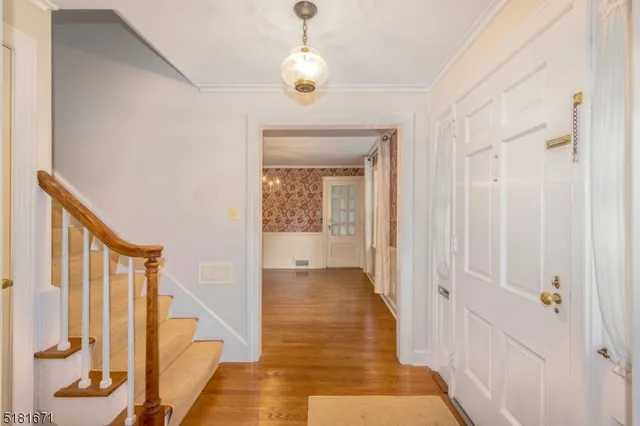 a view of a hallway with wooden floor and staircase
