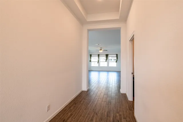 a view of a hallway with wooden floor and a floor to ceiling window