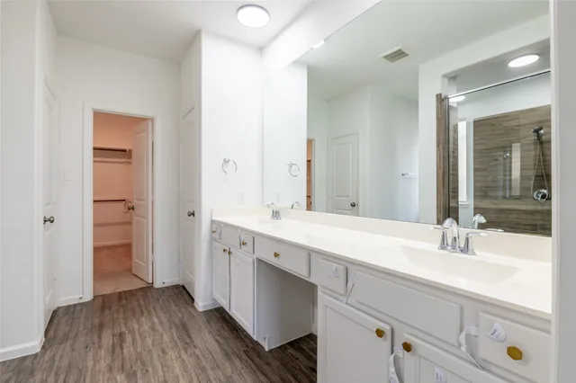 a spacious bathroom with a double vanity sink and mirror