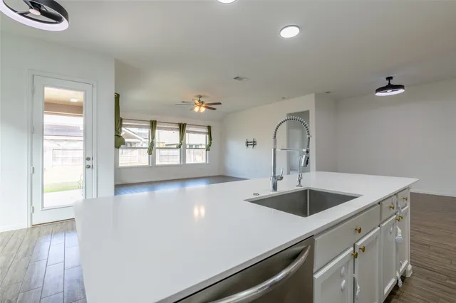 a kitchen with a sink and wooden floor