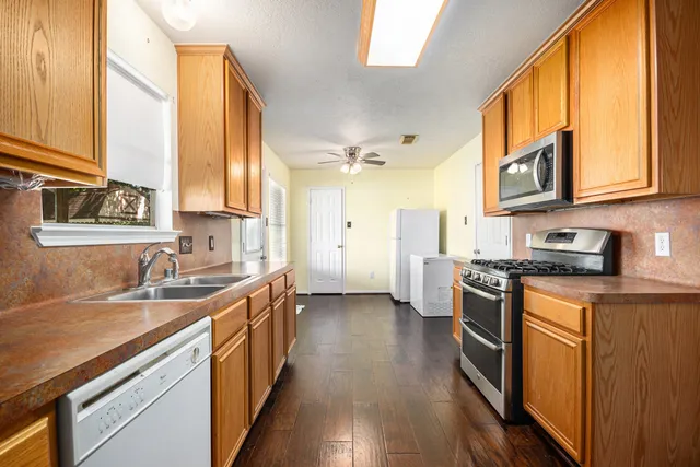a kitchen with stainless steel appliances granite countertop a sink a stove and a refrigerator