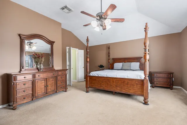 a bedroom with a large bed and a chandelier