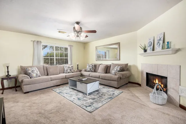 a living room with furniture a fireplace and a chandelier
