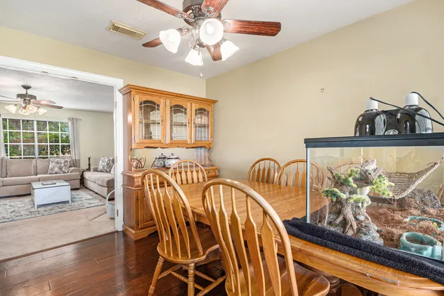 a view of a dining room with furniture a chandelier and wooden floor