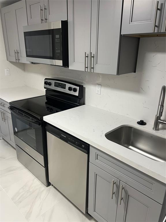 8705 Northwest 38th Drive, Unit 2A Coral Springs, FL 33065 - Photo 14 of 51 a kitchen with a sink and a microwave