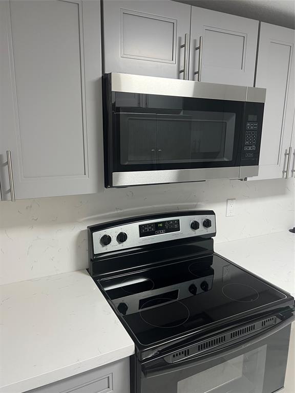 8705 Northwest 38th Drive, Unit 2A Coral Springs, FL 33065 - Photo 16 of 51 a stove top oven sitting inside of a kitchen
