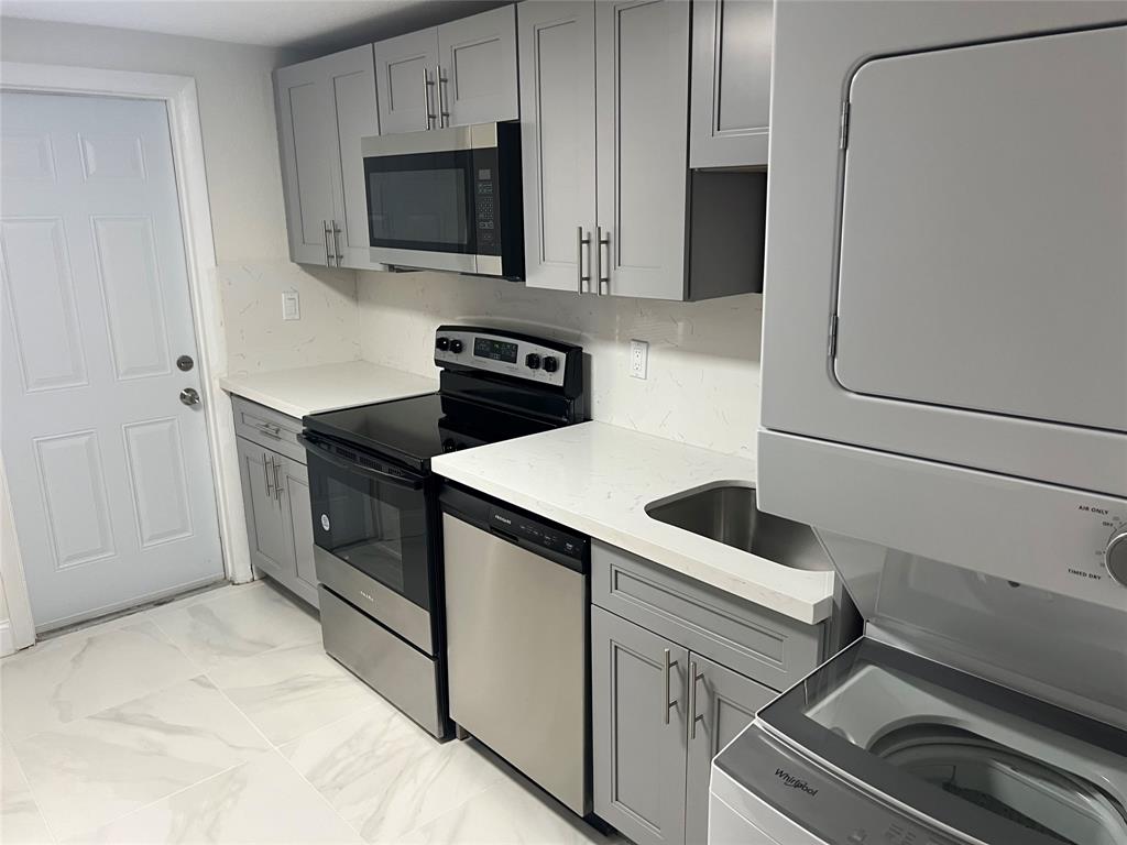 8705 Northwest 38th Drive, Unit 2A Coral Springs, FL 33065 - Photo 2 of 51 a kitchen with white cabinets and stainless steel appliances