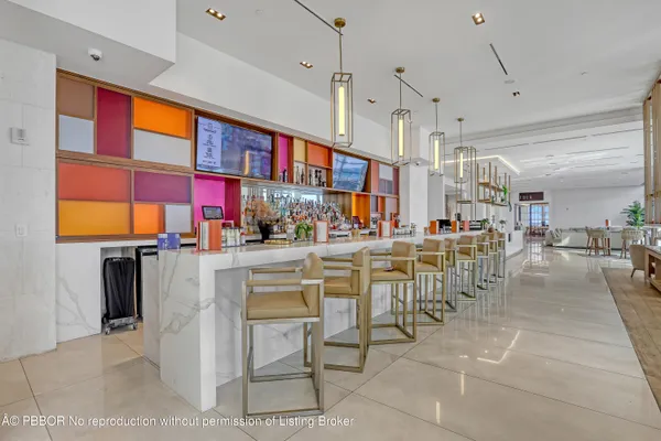 a dining hall with stainless steel appliances lots of white furniture