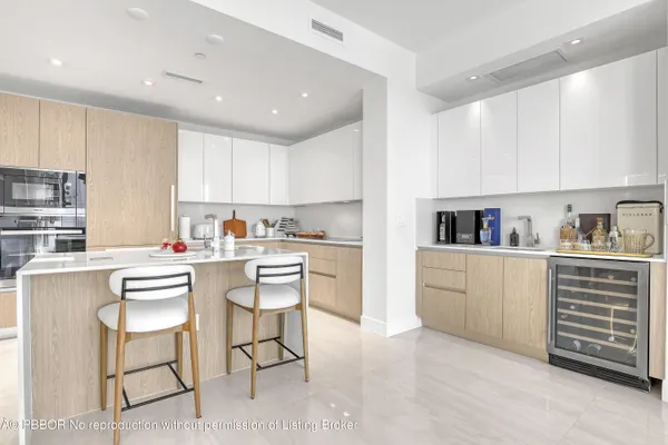 a kitchen with a white cabinets and chairs in it