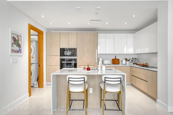 a kitchen that has a cabinets and chairs in it