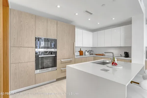 a kitchen with stainless steel appliances a refrigerator sink and white cabinets