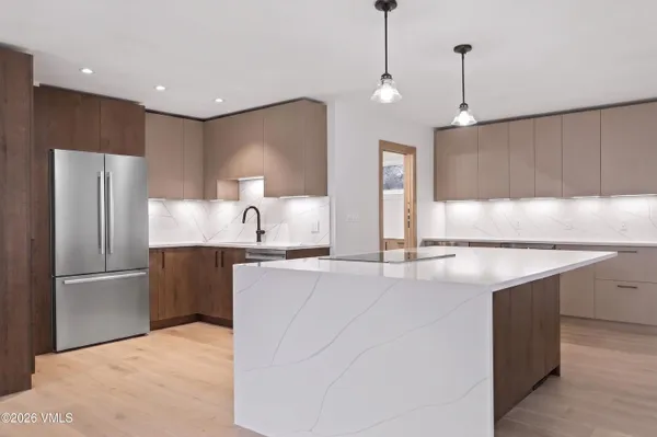 a kitchen with stainless steel appliances granite countertop a refrigerator a sink and a stove