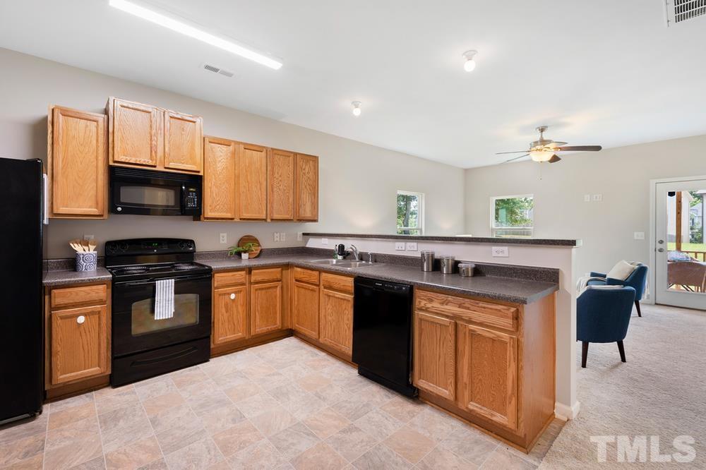 2520 Follow Me Way Raleigh, NC 27610 - Photo 7 of 30 a kitchen with stainless steel appliances granite countertop a stove top oven a sink dishwasher and a microwave oven on the blue kitchen countertops