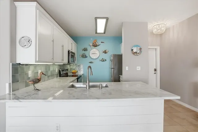 a kitchen with white cabinets and black appliances