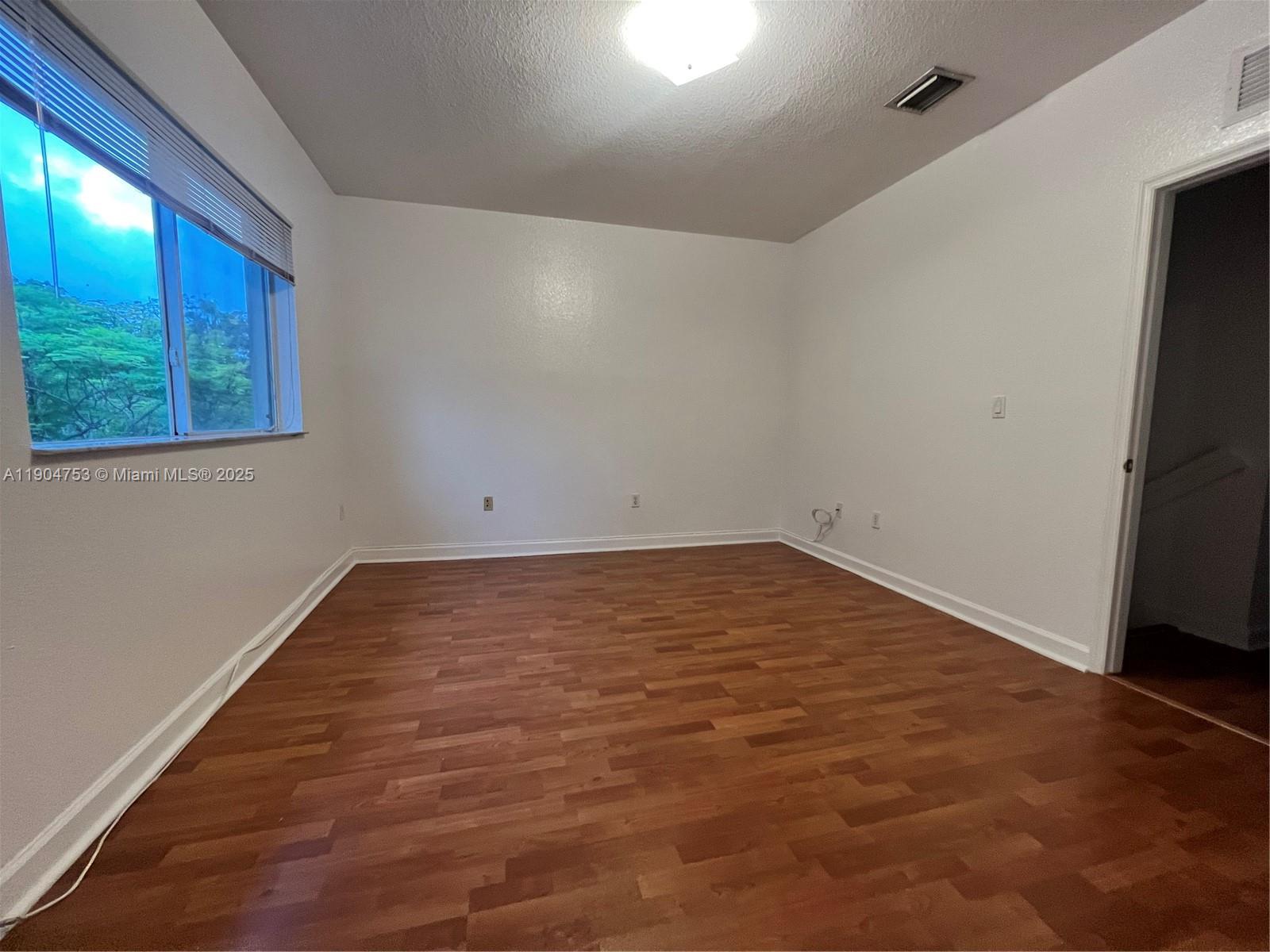 8564 Southwest 214th Way Cutler Bay, FL 33189 - Photo 13 of 31 a view of empty room with wooden floor