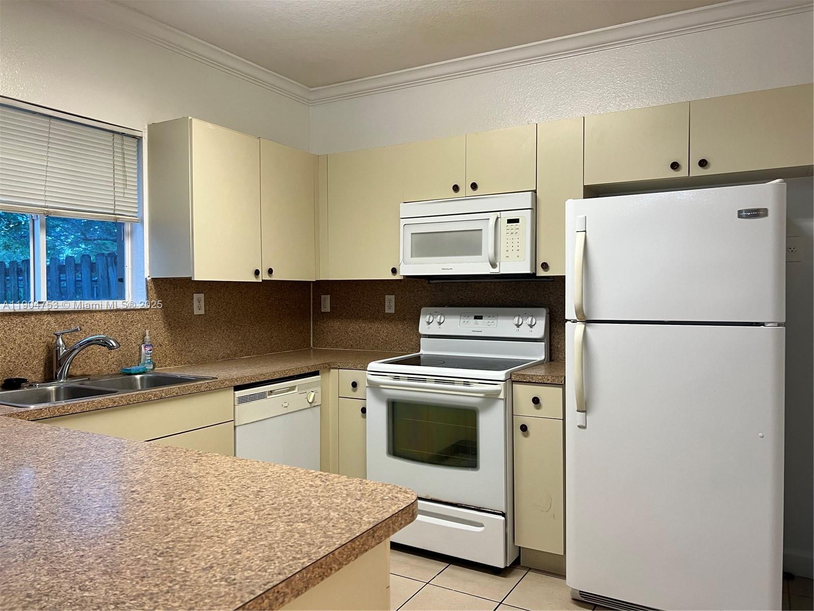 8564 Southwest 214th Way Cutler Bay, FL 33189 - Photo 20 of 31 a kitchen with a sink a stove and refrigerator