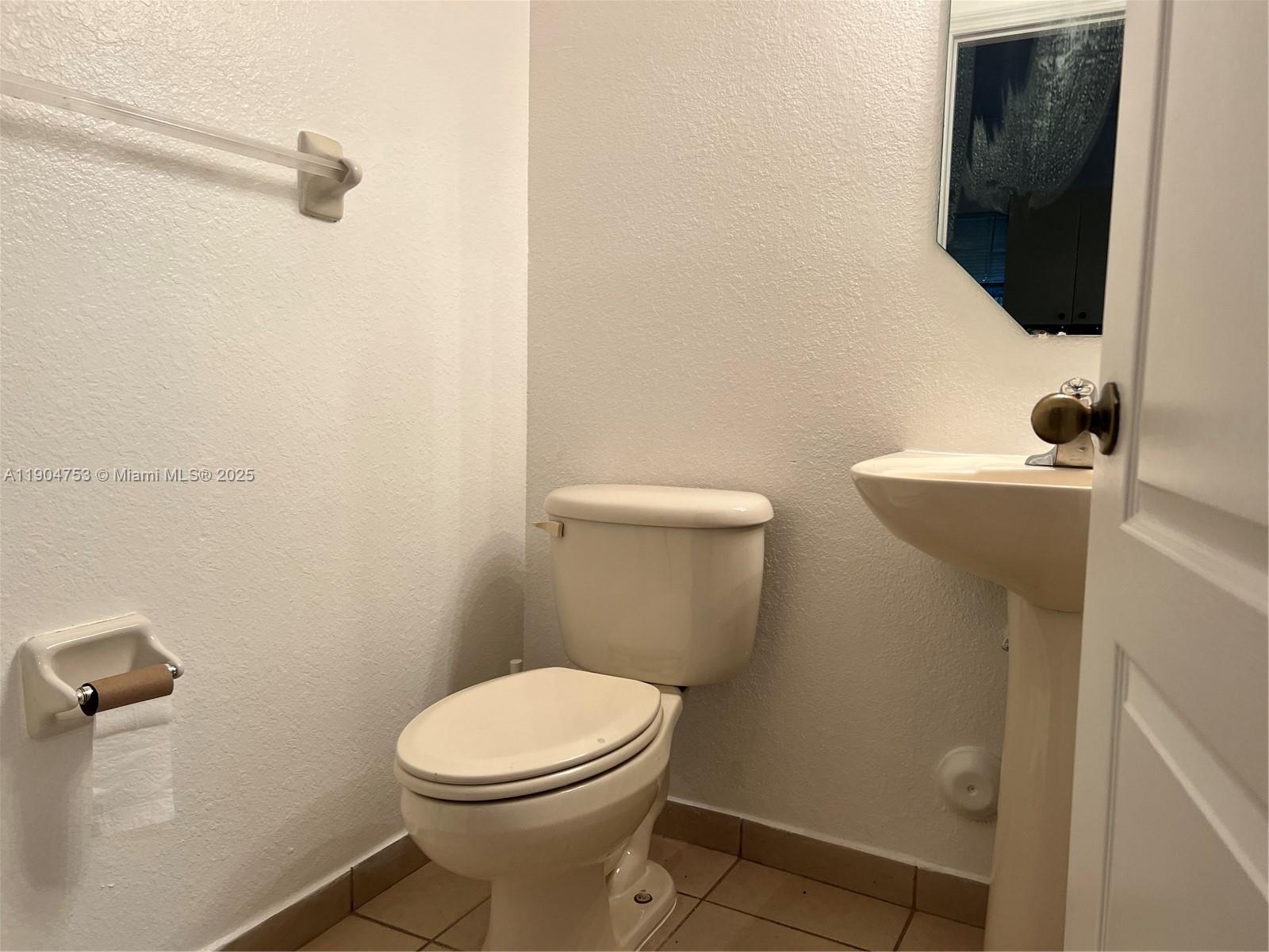 8564 Southwest 214th Way Cutler Bay, FL 33189 - Photo 22 of 31 a bathroom with a toilet a sink and mirror