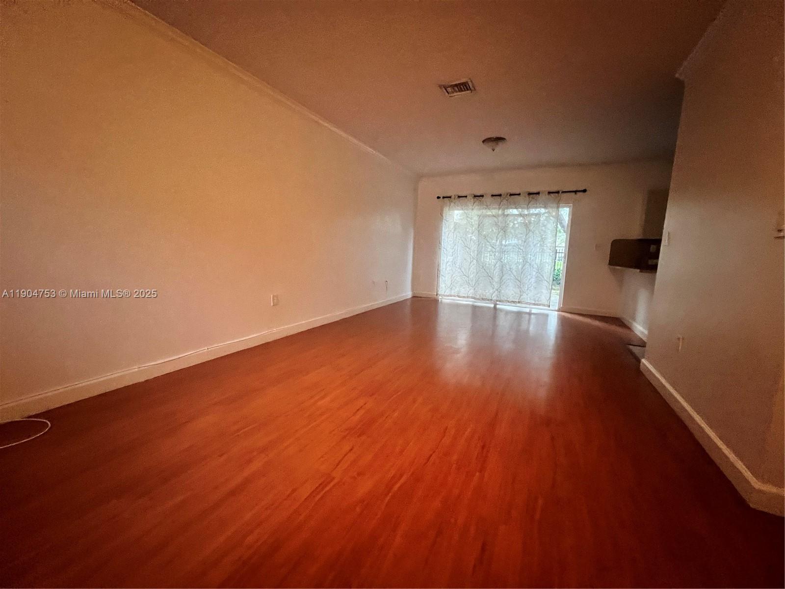 8564 Southwest 214th Way Cutler Bay, FL 33189 - Photo 25 of 31 an empty room with wooden floor and windows