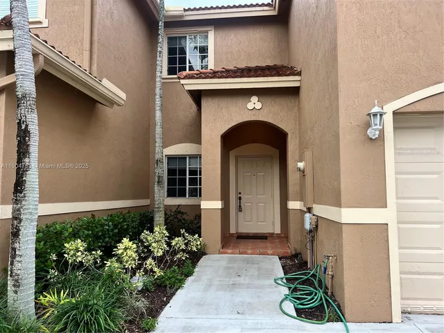 a front view of a house with plants