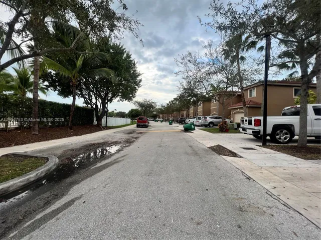 a view of road with card parked on side and road