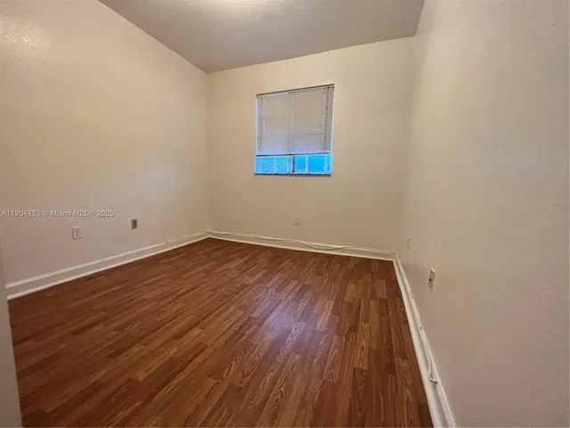 a view of a room with wooden floor and white walls