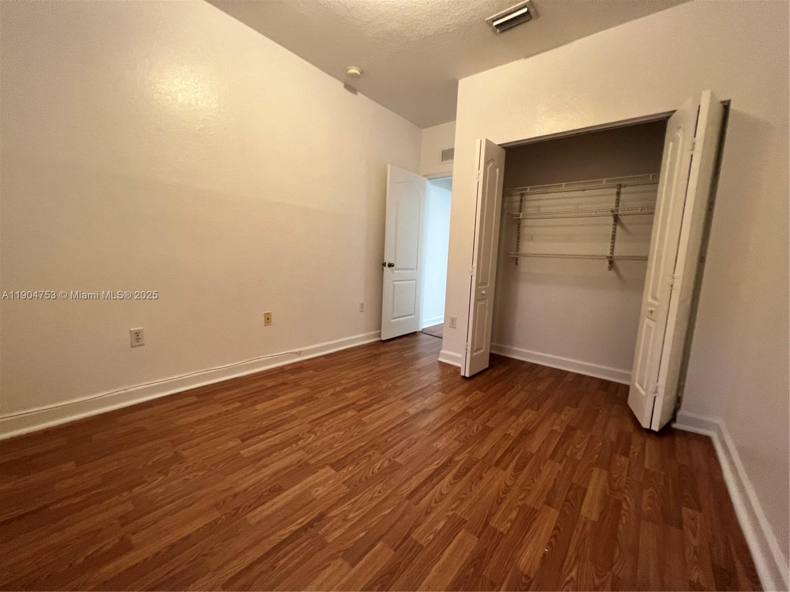 8564 Southwest 214th Way Cutler Bay, FL 33189 - Photo 9 of 31 an empty room with wooden floor and closet