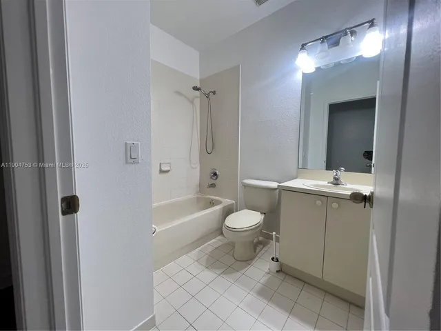 a bathroom with a toilet a sink a mirror a bathtub and vanity