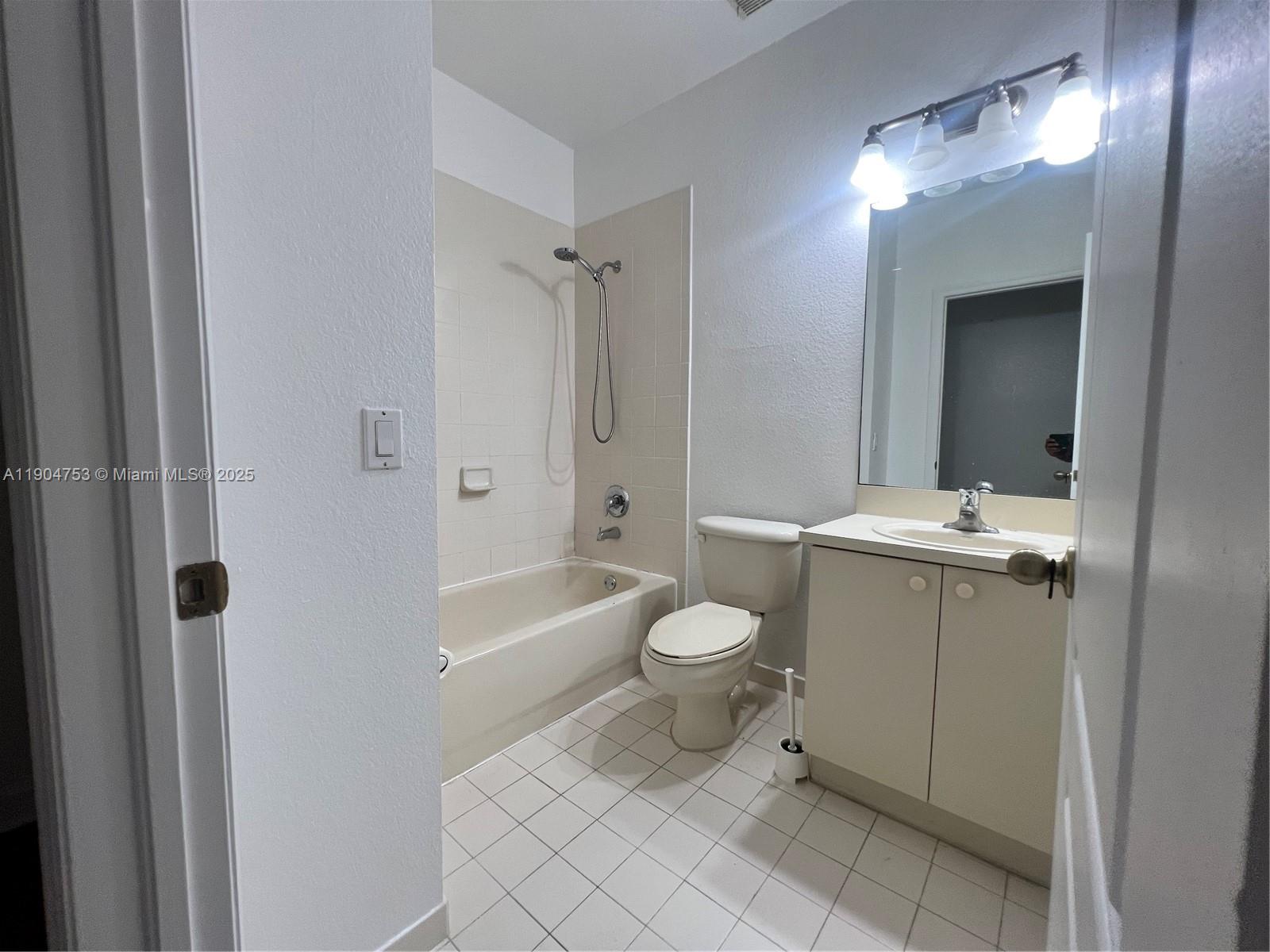 8564 Southwest 214th Way Cutler Bay, FL 33189 - Photo 10 of 31 a bathroom with a toilet a sink a mirror a bathtub and vanity