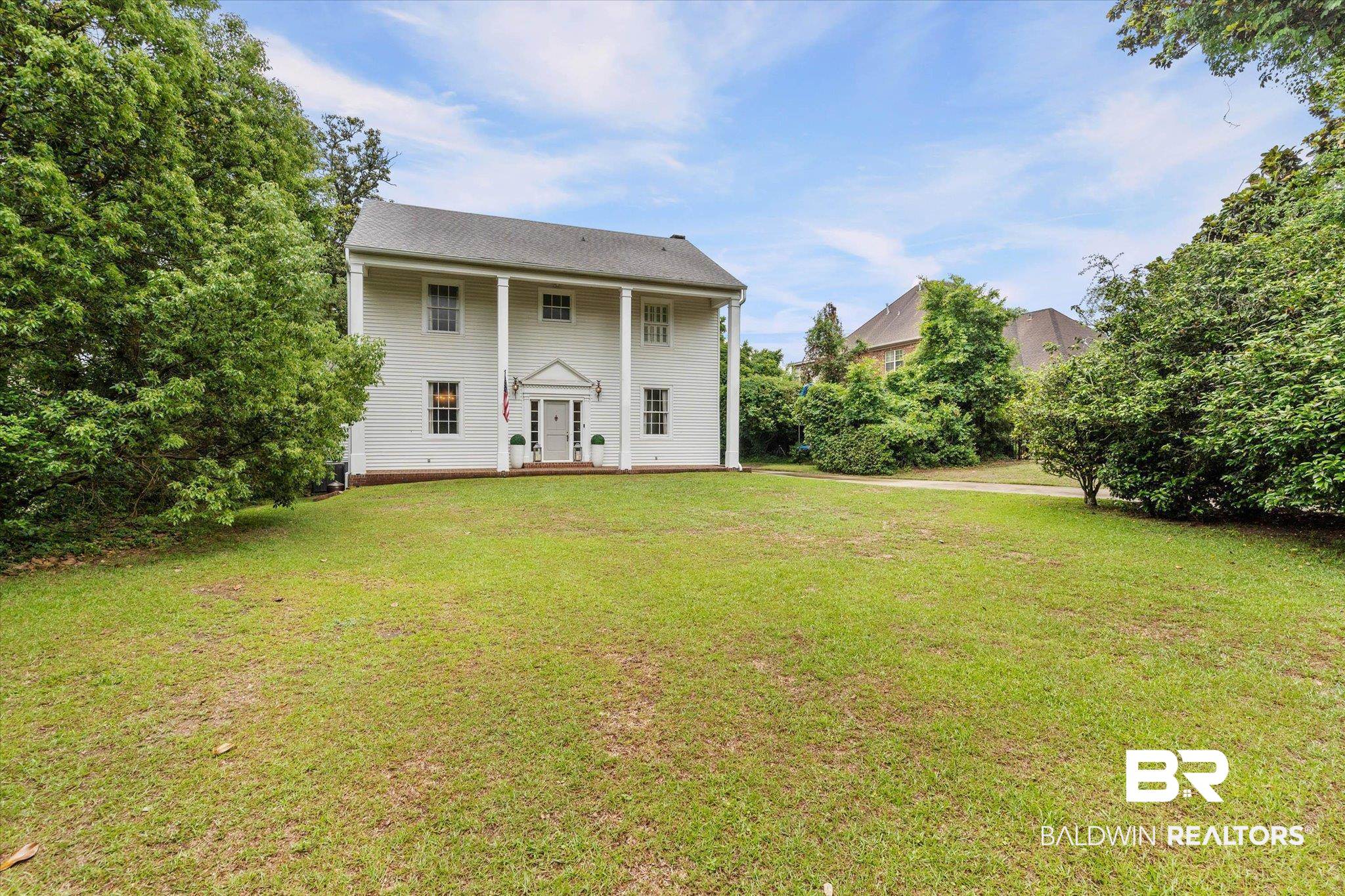 3863 Old Shell Road Mobile, AL 36608 - Photo 40 of 48 Traditional Colonial residence featuring a prominent portico with four white columns, a symmetrical facade with multiple windows, and a central front door with sidelights