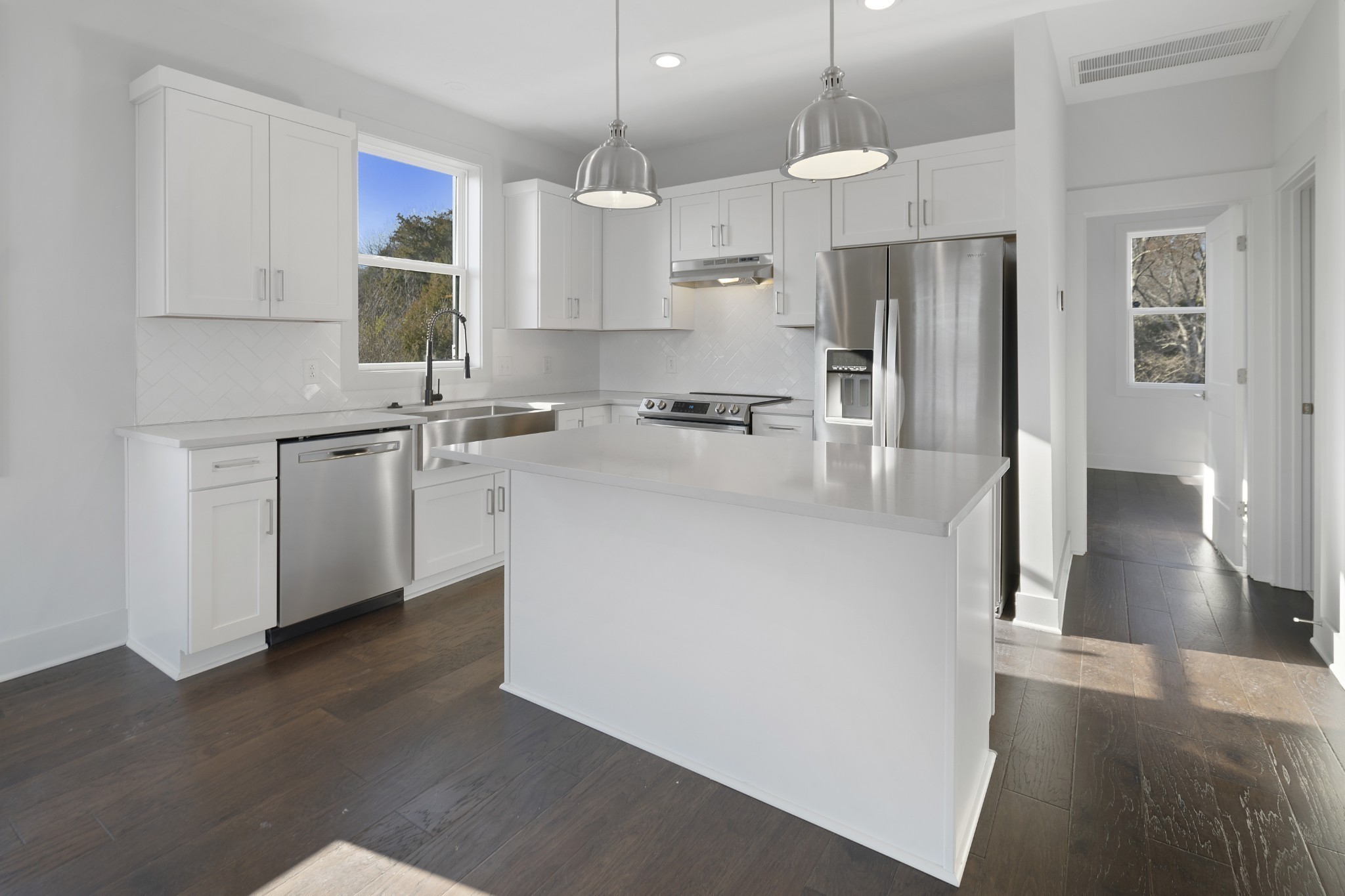 710 Inspiration Boulevard Madison, TN 37115 - Photo 17 of 43 a kitchen with stainless steel appliances a refrigerator a sink dishwasher a stove and white cabinets with wooden floor