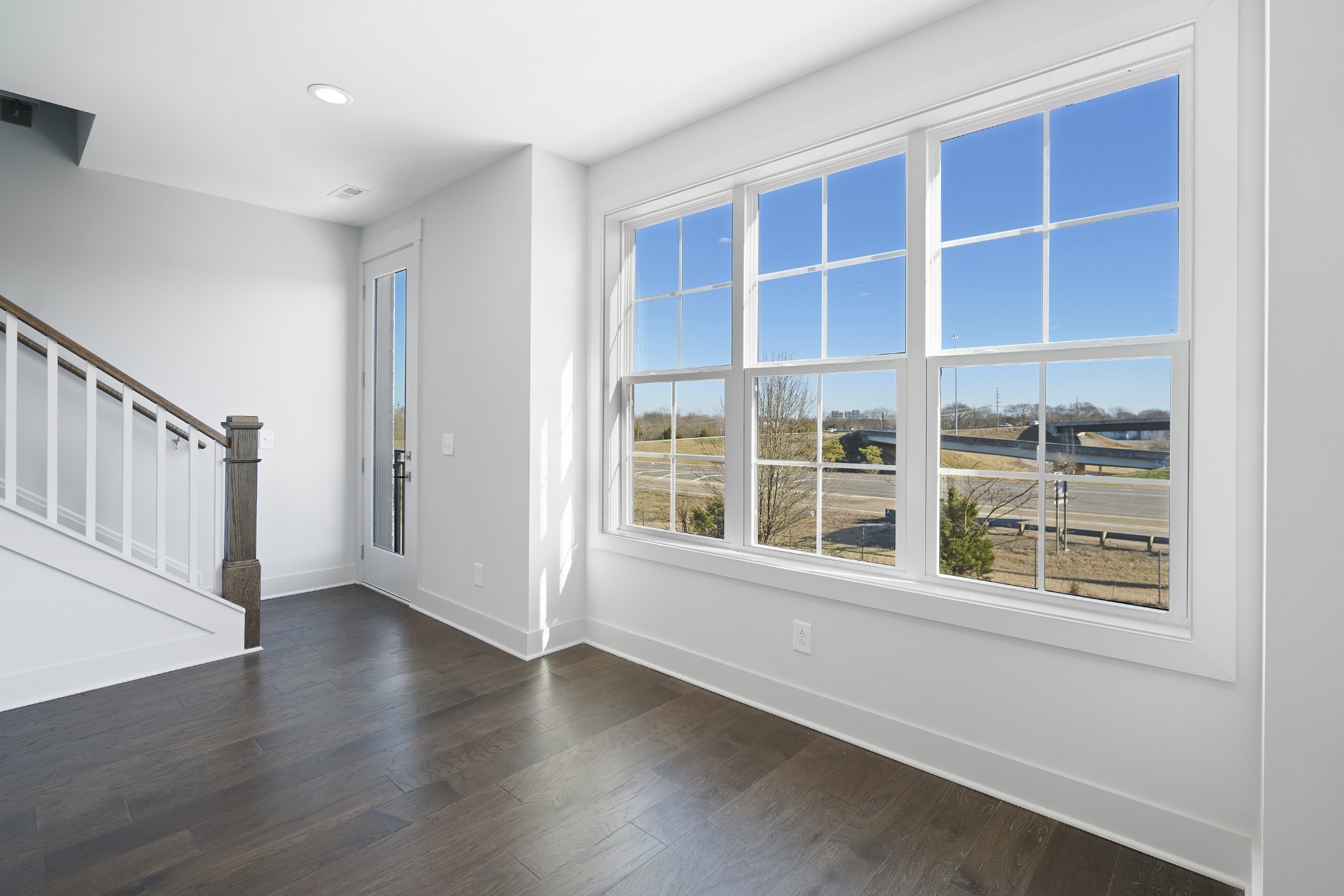 710 Inspiration Boulevard Madison, TN 37115 - Photo 6 of 43 a view of an empty room with wooden floor and windows