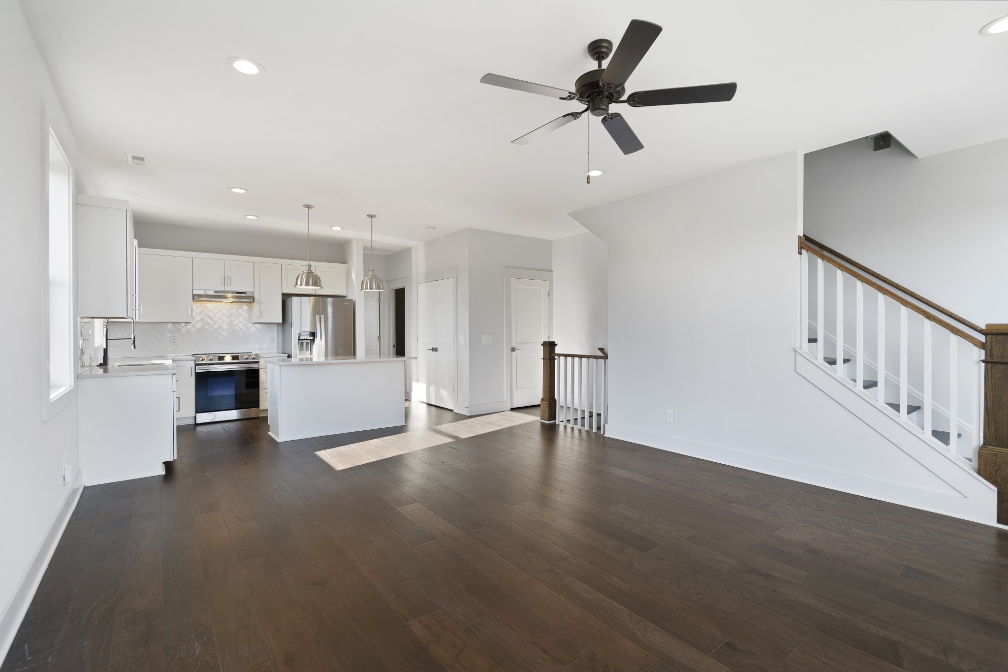 710 Inspiration Boulevard Madison, TN 37115 - Photo 10 of 43 a view of an empty room with kitchen view and wooden floor