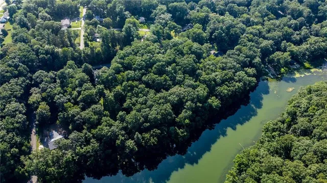 an aerial view of a house with a yard and lake view