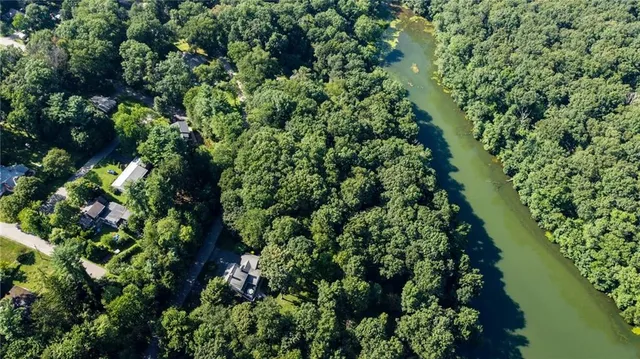 an aerial view of a house with a lush green forest
