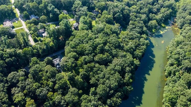 an aerial view of residential house with outdoor space and trees all around