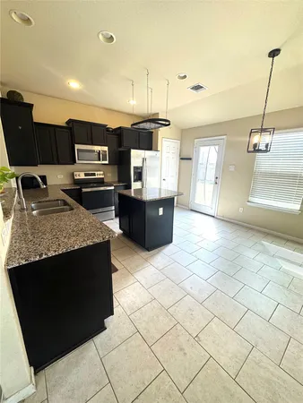 a kitchen with stainless steel appliances granite countertop a sink and a stove