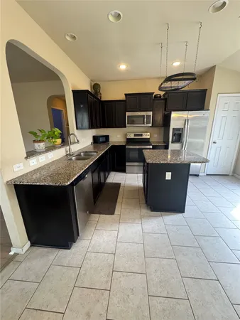 a kitchen with stainless steel appliances kitchen island granite countertop a sink and cabinets