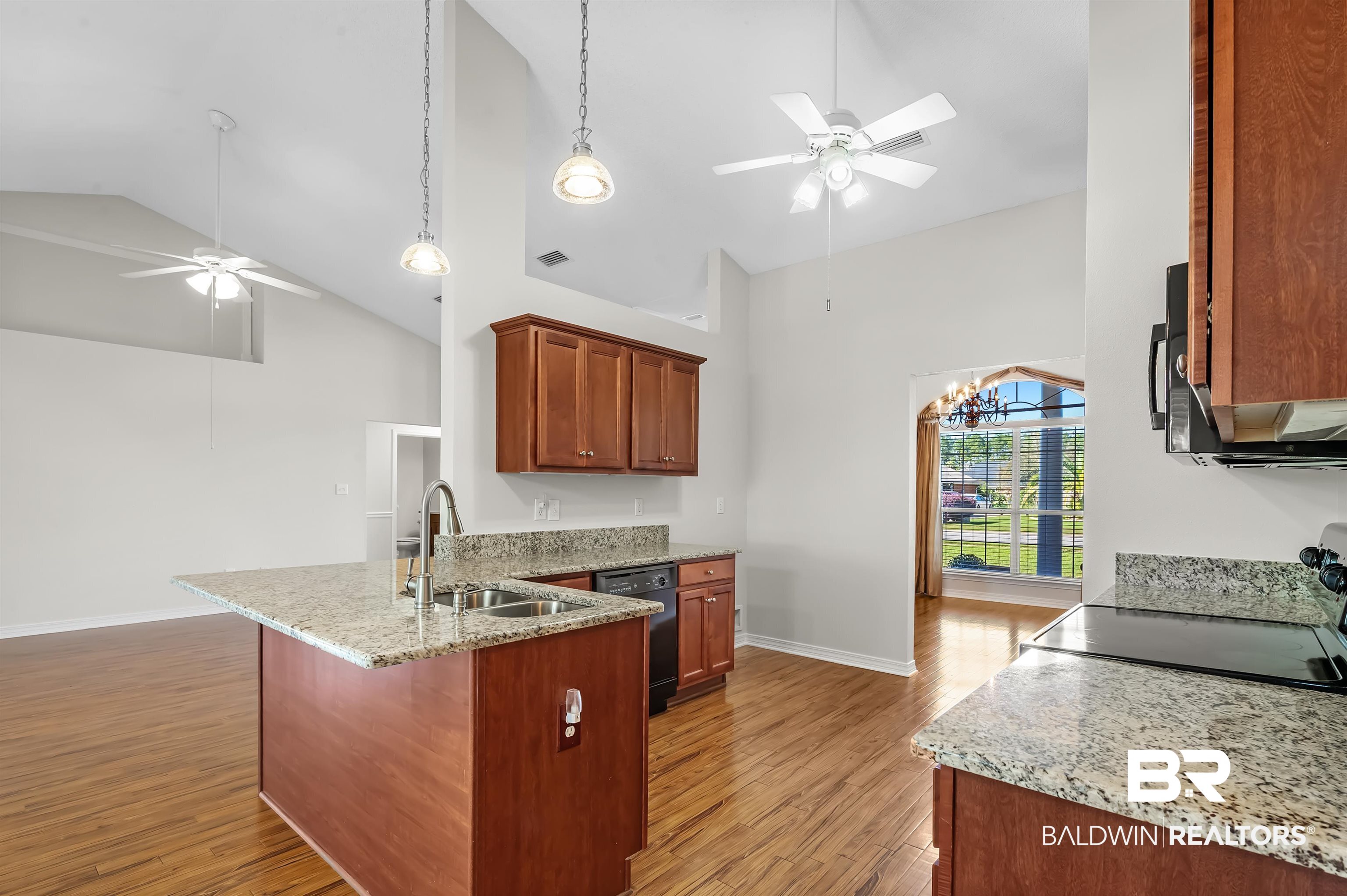 421 Collinwood Loop Foley, AL 36535 - Photo 30 of 62 Kitchen featuring sink, light stone countertops, black appliances, high vaulted ceiling, and light hardwood / wood-style floors