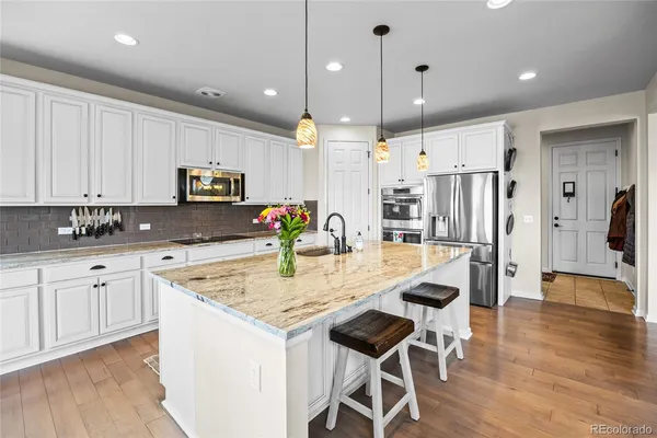 a kitchen with kitchen island granite countertop a sink a center island and stainless steel appliances