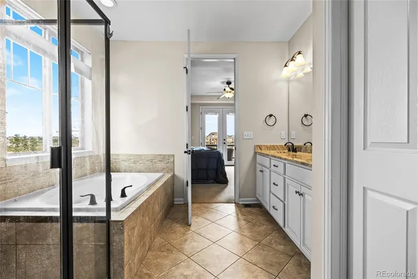 a bathroom with a tub a double vanity sink and mirror