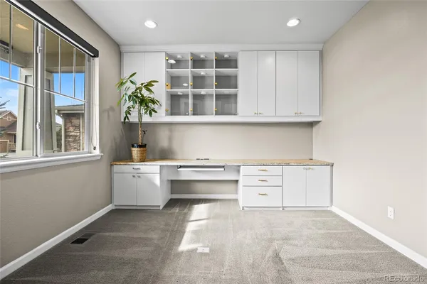 a kitchen with white cabinets and window